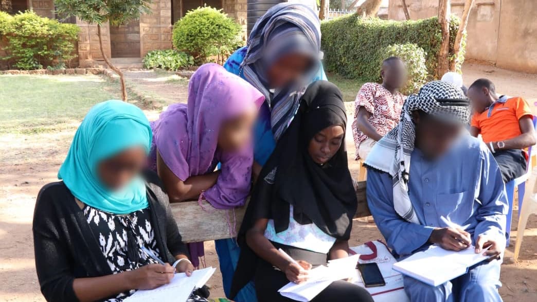 Group of women and men writing and studying together.