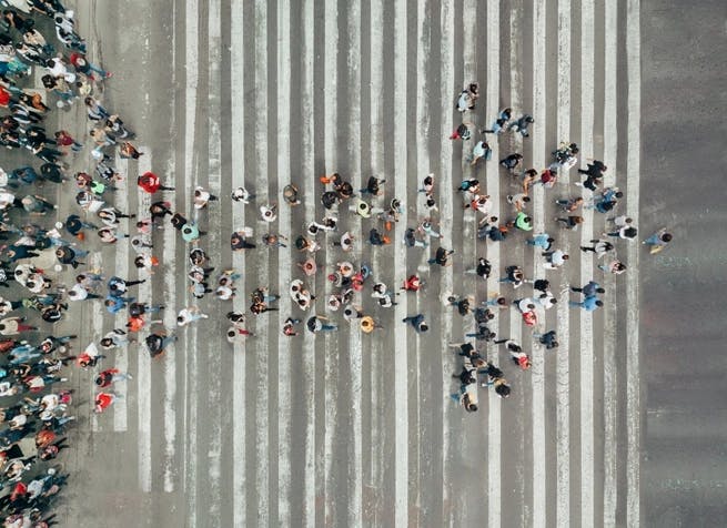 arrow made of people on crosswalk 