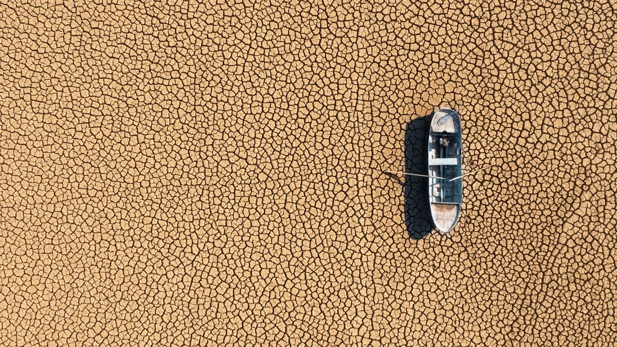 aerial view of empty rowboat on dry lakebed
