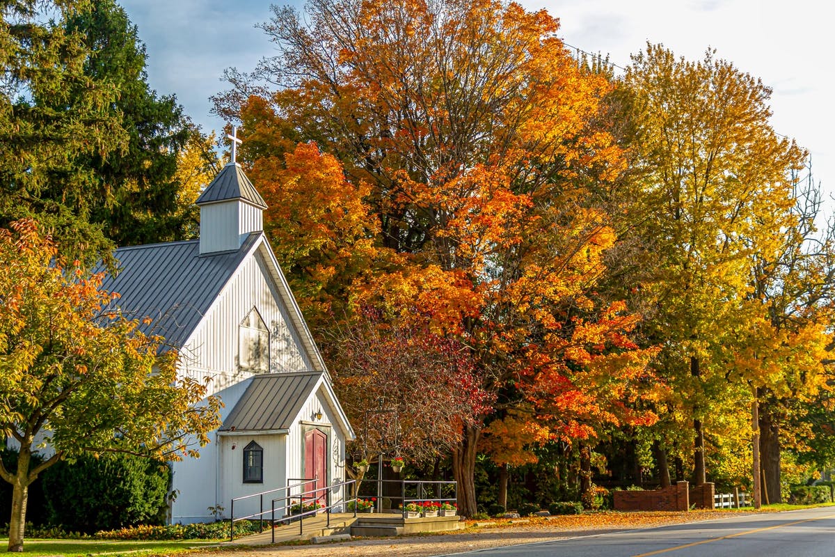 small white church building with fall trees around it