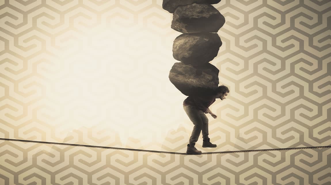 man on a tightrope with boulders on his back
