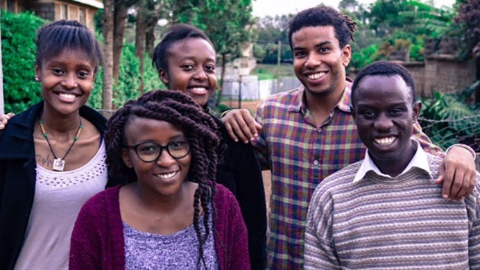 Group of young Kenyan men and women smiling at camera.
